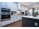 Modern kitchen featuring white cabinets, stainless steel appliances, and a gray quartz island at 4304 Fly Rod Ter, Parrish, FL 34219