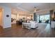 Open concept living room and kitchen with hardwood floors, white cabinets, and sliding doors to the lanai at 4304 Fly Rod Ter, Parrish, FL 34219