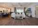 Open living room showcasing a large sectional sofa, hardwood floors, and views to the kitchen and backyard at 4304 Fly Rod Ter, Parrish, FL 34219