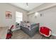 Bright bedroom with a gray bed frame, red chairs, and a desk at 4917 Sabal Lake Cir, Sarasota, FL 34238