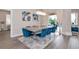 Bright dining room with large table and blue velvet chairs, overlooking pool at 4917 Sabal Lake Cir, Sarasota, FL 34238