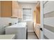 Clean laundry room with washer, dryer, wooden cabinets, and window at 4917 Sabal Lake Cir, Sarasota, FL 34238