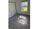 Bright bedroom with window, closet, and wood-look tile floor at 506 Houle Ave, Sarasota, FL 34232