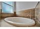 Oval bathtub with tile surround in a modern bathroom at 5607 Tidewater Preserve Blvd, Bradenton, FL 34208