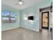 Bedroom with light teal walls, tile floor, and exterior access at 5607 Tidewater Preserve Blvd, Bradenton, FL 34208