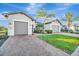 Home's exterior showcases gray siding, a three-car garage, and a neatly landscaped lawn at 5607 Tidewater Preserve Blvd, Bradenton, FL 34208