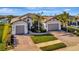 Two-car garage, palm trees, and attractive landscaping at 5607 Tidewater Preserve Blvd, Bradenton, FL 34208