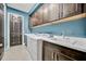 Laundry room with dark cabinets, washer, dryer, and utility sink at 5607 Tidewater Preserve Blvd, Bradenton, FL 34208