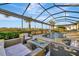 Relaxing patio with fire pit, covered lanai, and refreshing pool with waterfall feature at 5607 Tidewater Preserve Blvd, Bradenton, FL 34208