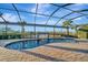 Relaxing pool and spa with waterfall feature, screened enclosure, and brick pavers at 5607 Tidewater Preserve Blvd, Bradenton, FL 34208