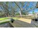 Peaceful backyard deck with large shade tree and open grassy area at 5701 Deer Hollow W Ln, Sarasota, FL 34232