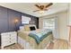 Spacious bedroom with a comfortable bed, dark-blue accent wall and ceiling fan at 5701 Deer Hollow W Ln, Sarasota, FL 34232