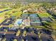 An aerial view of the community pool, tennis courts, and golf course in a well-maintained neighborhood at 5724 Doral Dr, Sarasota, FL 34243