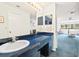 Bathroom featuring blue countertops with dual mirrors, vanity storage, and light fixtures at 5724 Doral Dr, Sarasota, FL 34243