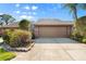 Home exterior featuring a two-car garage, well-maintained landscaping, and a private driveway at 5724 Doral Dr, Sarasota, FL 34243