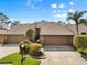 Exterior home view shows a two-car garage, mature landscaping and a well-manicured lawn at 5724 Doral Dr, Sarasota, FL 34243