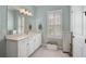 Bright bathroom with a vanity, a large mirror, and a window with shutters at 6625 Dovekey Dr, Sarasota, FL 34241