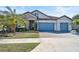 Two-story house with light gray walls and blue garage doors at 6625 Dovekey Dr, Sarasota, FL 34241