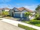 Beautiful home exterior with three-car garage and landscaping at 6625 Dovekey Dr, Sarasota, FL 34241