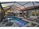 Luxury pool and spa with covered patio, fire pit, and lake view at 6625 Dovekey Dr, Sarasota, FL 34241