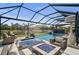 Amazing pool and patio area with a screened enclosure, fire pit, and lake view at 6625 Dovekey Dr, Sarasota, FL 34241