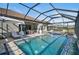 Luxury pool with a screened enclosure, fire pit, and lake view at 6625 Dovekey Dr, Sarasota, FL 34241