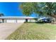 Front view of charming villa with 2-car garage, lush lawn and mature tree at 6704 11Th W Ave, Bradenton, FL 34209