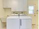 Bright laundry room with washer, dryer, cabinets, and sink at 6704 11Th W Ave, Bradenton, FL 34209