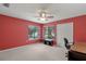 Multipurpose bedroom or office space with red accent wall and built-in desk at 7340 Silver Fern Blvd # 5, Sarasota, FL 34241
