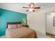 Bedroom with teal accent wall, ceiling fan, and ample natural light at 7340 Silver Fern Blvd # 5, Sarasota, FL 34241