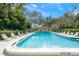 Refreshing community pool with lounge chairs and shaded seating area at 7340 Silver Fern Blvd # 5, Sarasota, FL 34241