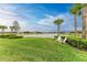 Serene backyard with lush grass, palm trees and a lake view at 9048 Bernini Pl, Sarasota, FL 34240
