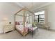 Main bedroom with a canopy bed and lake view at 9048 Bernini Pl, Sarasota, FL 34240