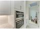 Double oven and microwave combo in a white kitchen at 9048 Bernini Pl, Sarasota, FL 34240
