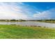 Scenic view of lake and homes with lush green grass at 9048 Bernini Pl, Sarasota, FL 34240
