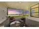 Covered patio with wicker furniture and a stunning sunset view at 9048 Bernini Pl, Sarasota, FL 34240