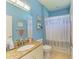 Light blue bathroom with granite vanity, shower/tub combo and decorative shower curtain at 11306 77Th E St, Parrish, FL 34219