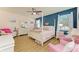 Main bedroom with a post bed, two pink accent chairs, and ceiling fan at 11306 77Th E St, Parrish, FL 34219