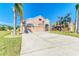 Tan house with three-car garage, red door, and palm trees at 11306 77Th E St, Parrish, FL 34219