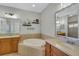 Elegant bathroom with double sinks, a large soaking tub, and modern fixtures at 11467 Conch Ct, Venice, FL 34292