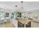 Open concept kitchen with granite island, stainless steel appliances, and white cabinets at 11467 Conch Ct, Venice, FL 34292