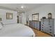 Serene main bedroom with king-size bed, dresser, and access to bathroom at 11467 Conch Ct, Venice, FL 34292