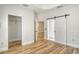 Bedroom with barn door, closet, and wood-look floors at 1378 Daryl Dr, Sarasota, FL 34232