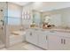 Bathroom with double vanity and large mirror at 17633 Cantarina Cv, Bradenton, FL 34211
