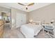 Bright bedroom with a queen bed, ceiling fan, and built-in workspace at 17633 Cantarina Cv, Bradenton, FL 34211