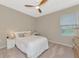 Cozy bedroom with a queen bed, ceiling fan, and built-in workspace at 17633 Cantarina Cv, Bradenton, FL 34211