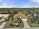 Aerial view of single-story home with tile roof, landscaping, and golf course views at 1985 White Feather Ln, Nokomis, FL 34275