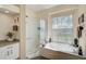 Spa-like bathroom with soaking tub, walk-in shower, and granite vanity at 1985 White Feather Ln, Nokomis, FL 34275