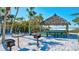 Beachfront grilling area with thatch-roofed gazebo at 20 Whispering Sands Dr # 306, Sarasota, FL 34242
