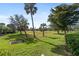 Large backyard with open green space and mature trees at 204 Venice Palms Blvd, Venice, FL 34292